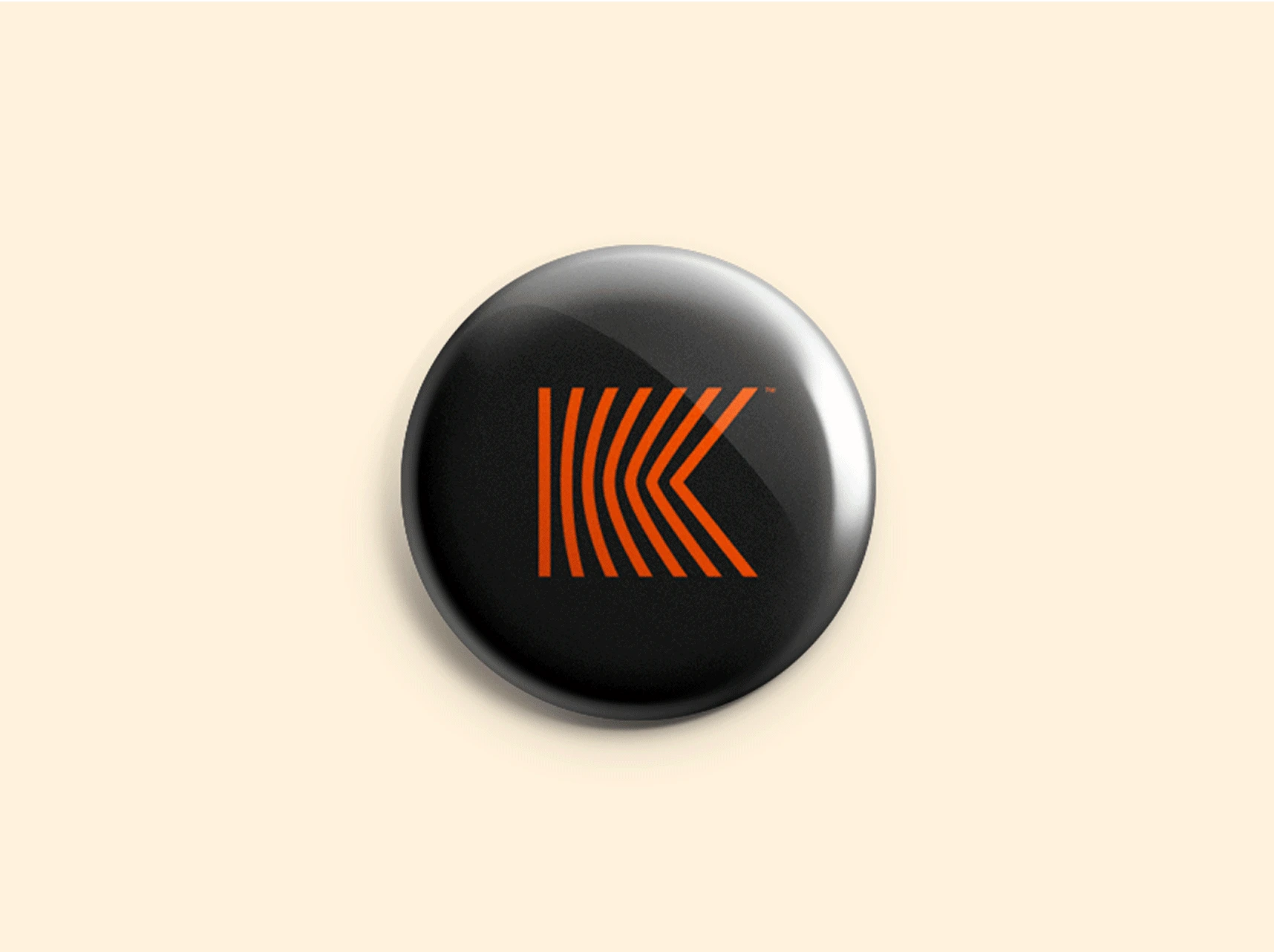 Black Kove pin with orange striped K logo.
