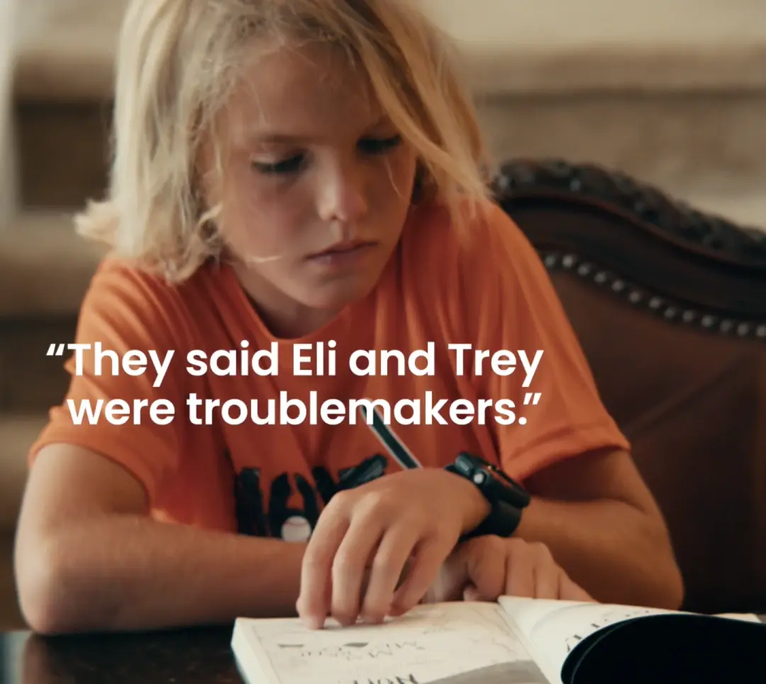 Boy reading a book with text: "They said Eli and Trey were troublemakers.