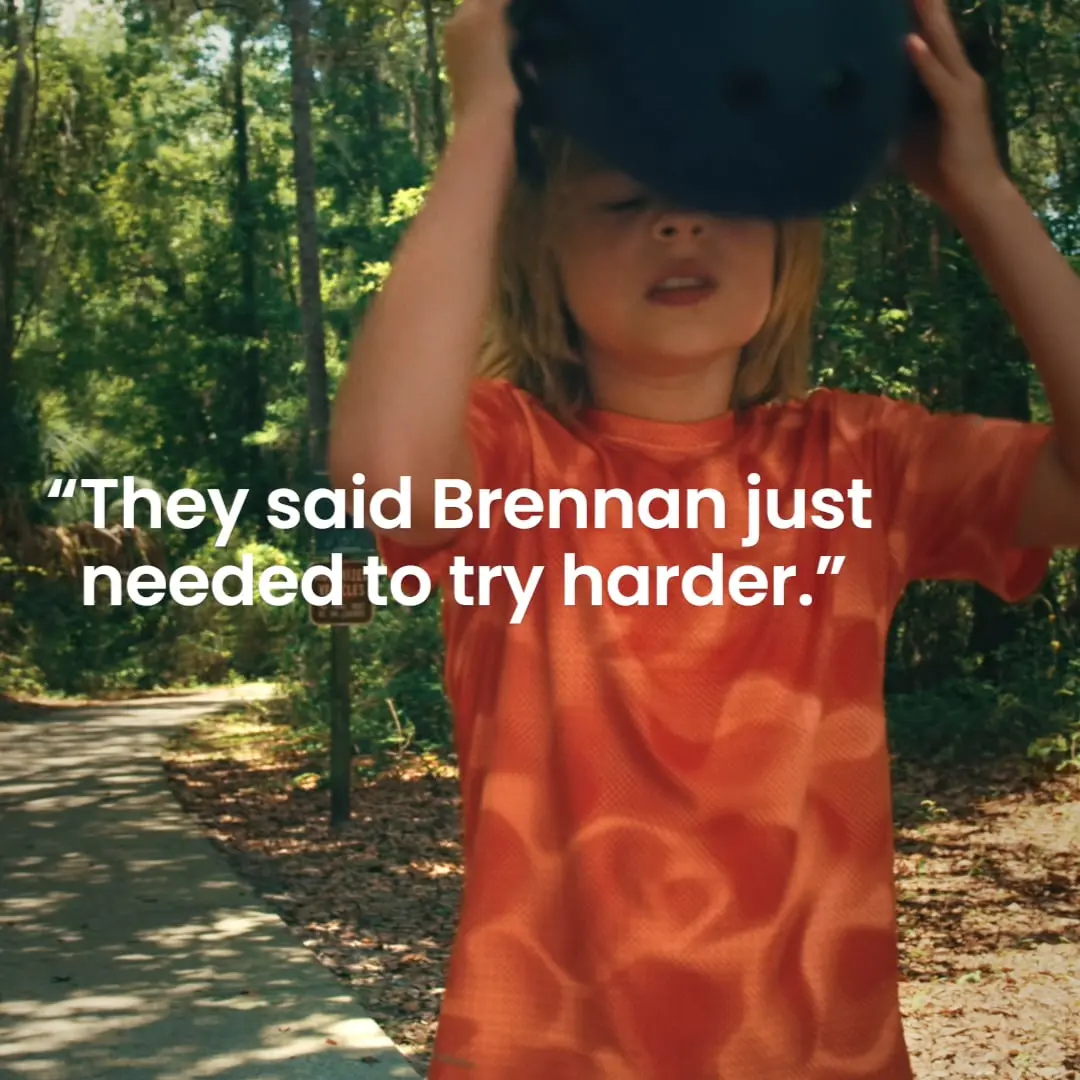 Boy putting on helmet, text: "They said Brennan just needed to try harder.