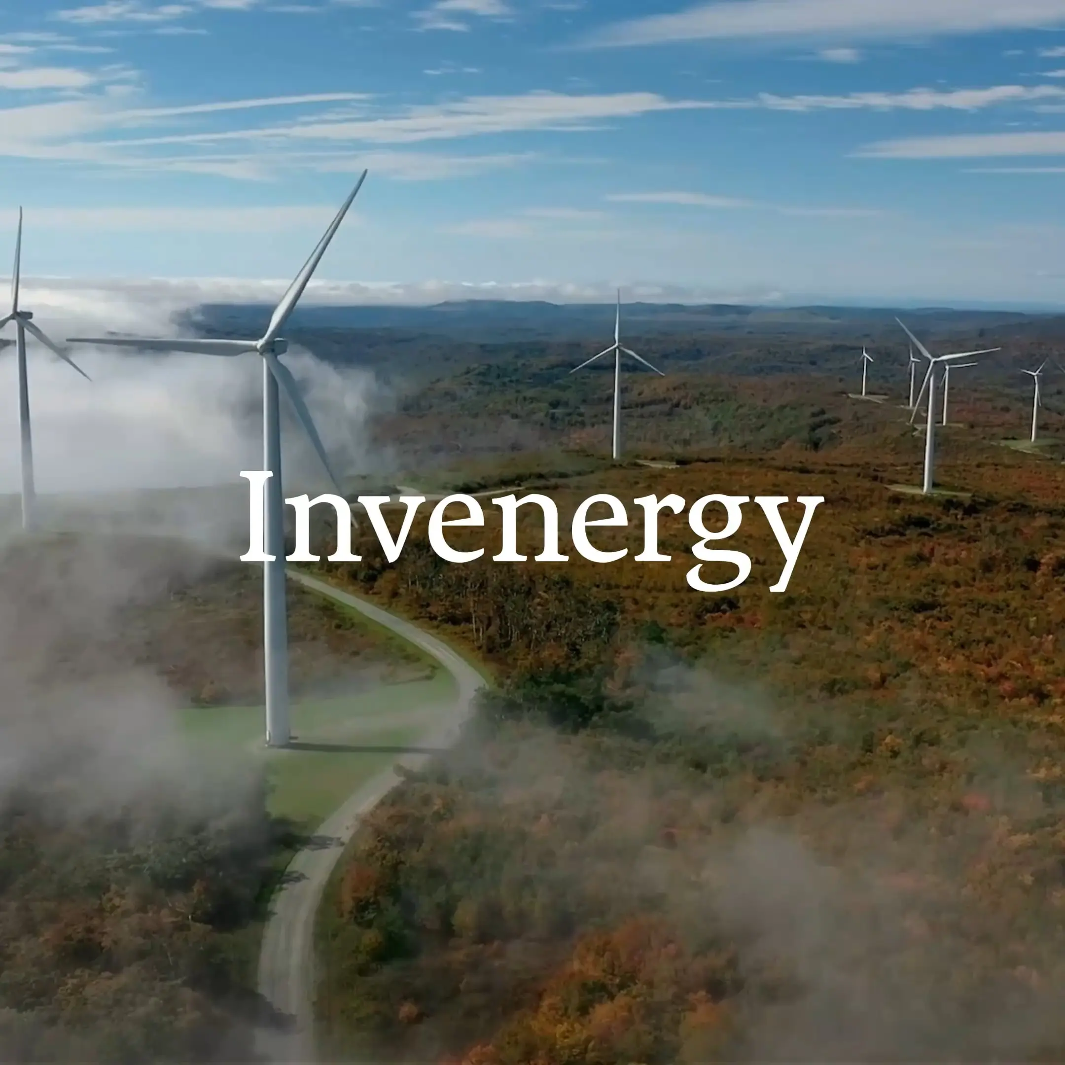 Invenergy wind turbines on a foggy, forested hillside.