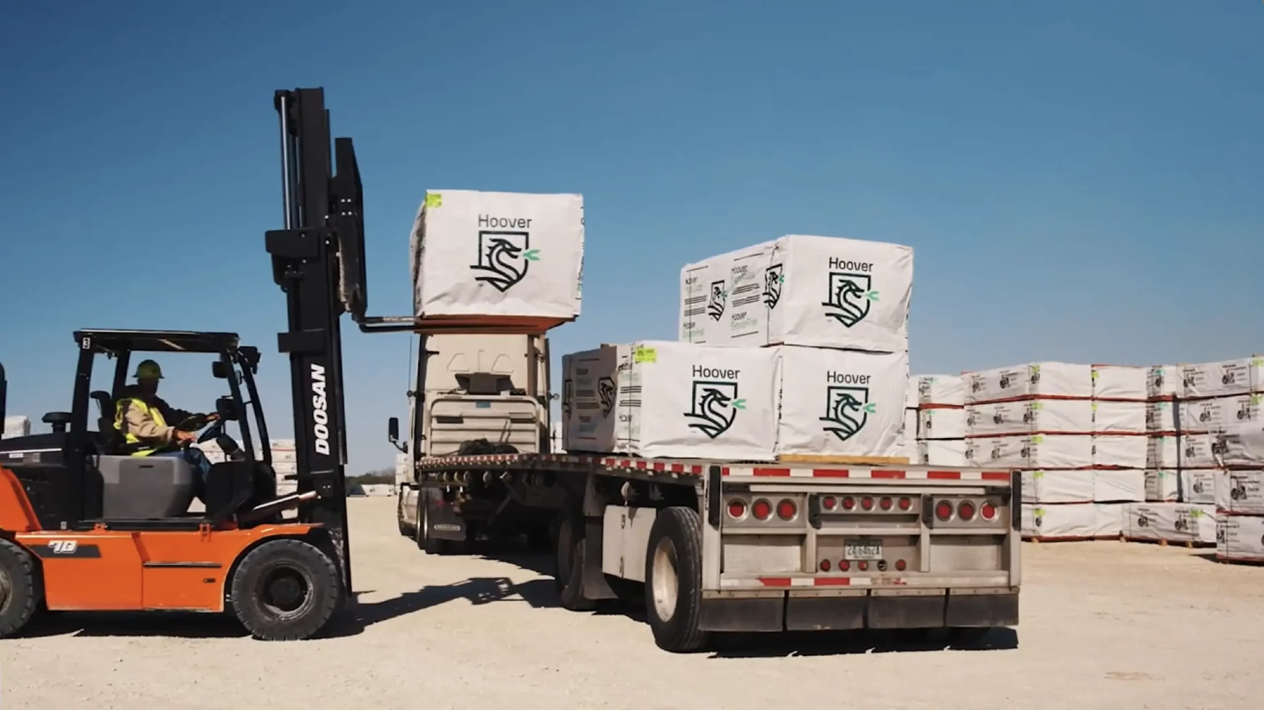 Forklift loading Hoover lumber onto a flatbed truck.